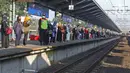 Calon penumpang KRL Commuter Line antre menunggu kedatangan kereta di Stasiun Bekasi, Selasa (5/5/2020). Pihak Stasiun Bekasi menerapkan jaga jarak antar penumpang, membatasi jumlah penumpang hingga 50% dan membatasi jam operasional dari pukul 06.00 hingga 18.00. (Liputan6.com/Herman Zakharia)