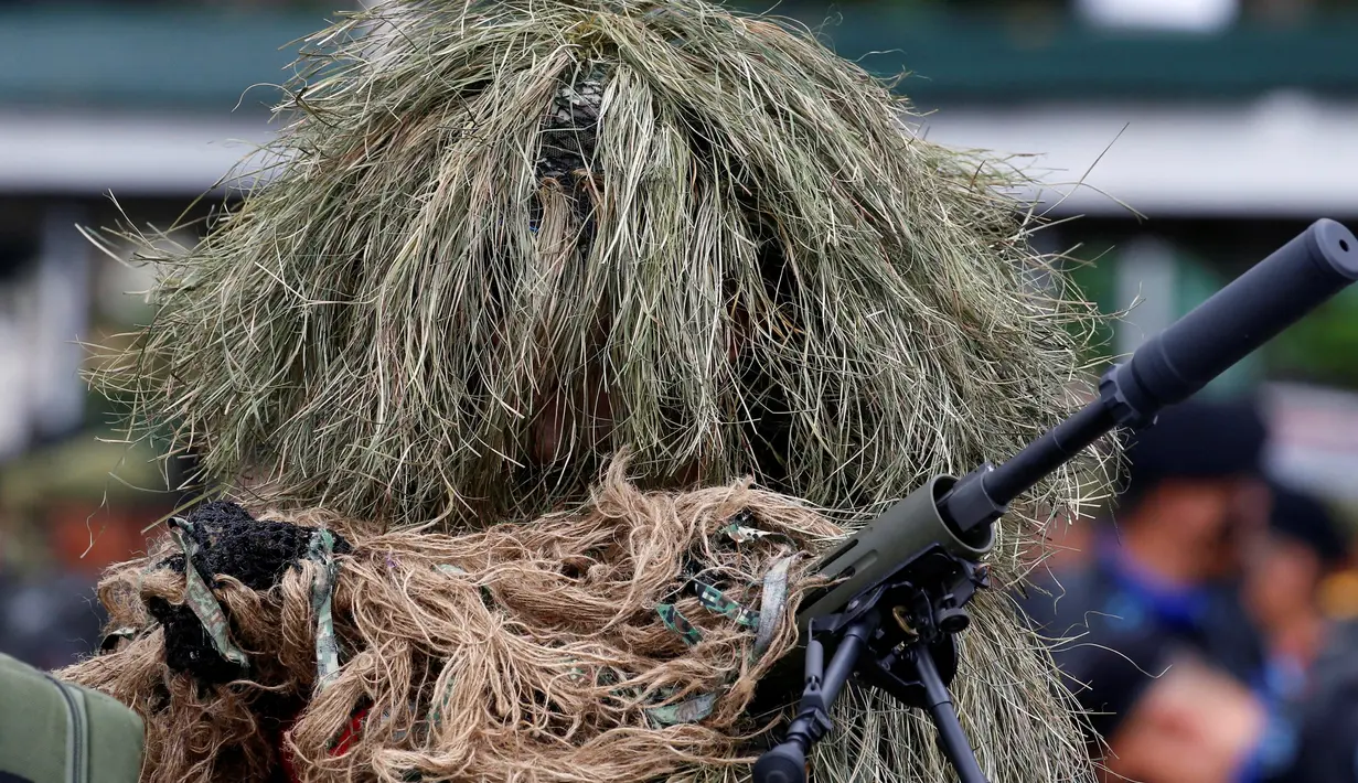 Seorang tentara penembak jitu mengenakan pakaian kamuflase saat mengikuti upacara pergantian Kepala Angkatan Bersenjata di kamp militer di Kota Quezon, Manila, Filipina (7/12). (Reuters/Erik De Castro)