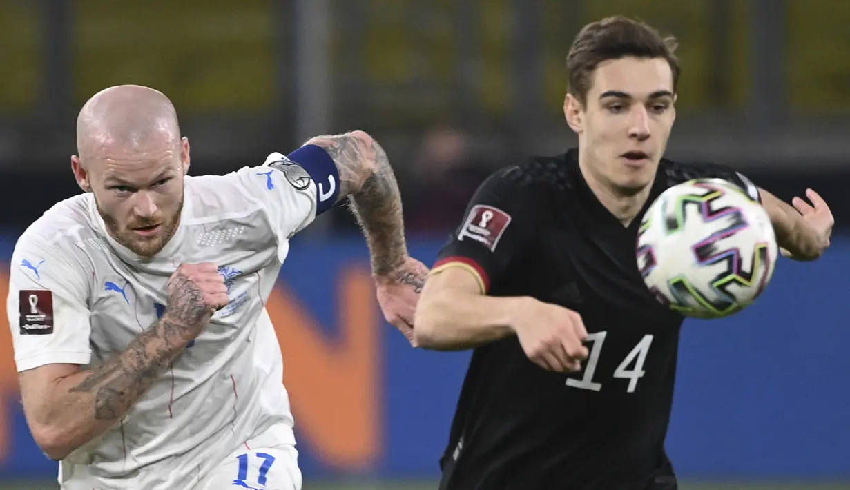 Gelandang Islandia Aron Gunnarsson (kiri) dan gelandang Jerman Florian Neuhaus bersaing memperebutkan bola pada pertandingan kualifikasi Piala Dunia 2022 Zona Eropa Grup J di Duisburg, Jumat (26/3/2021) dinihari WIB. Jerman berhasil melumat Islandia dengan skor 3-0. (Ina Fassbender/AFP)