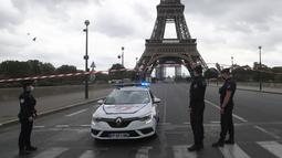Petugas polisi Prancis mengamankan jembatan menuju Menara Eiffel di Paris, Rabu (23/9/2020). Polisi Paris telah memblokir daerah sekitar Menara Eiffel setelah ancaman bom telepon. (AP Photo / Michel Euler)
