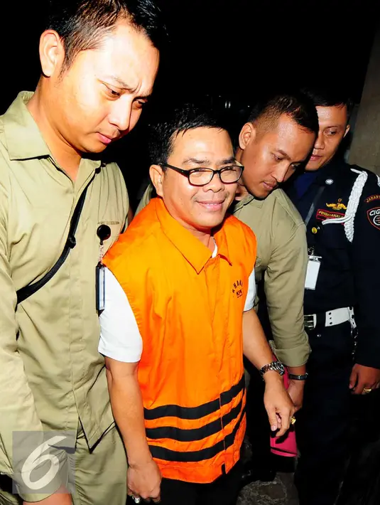 Anggota DPRD Riau periode 2009-2014 Ahmad Kirjauhari dikawal petugas seusai menjalani pemeriksaan di gedung KPK, Jakarta, Rabu (16/9). KPK menahan Ahmad Kirjauhari terkait kasus suap RAPBD Provinsi Riau Tahun 2014-2015. (Liputan6.com/Helmi Afandi)