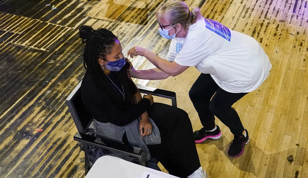 Seseorang menerima suntikan vaksin Pfizer di pusat vaksinasi Covid pop-up, yang didirikan di klub malam Heaven di London, Minggu (8/8/2021). Heaven menjadi klub malam pertama di Inggris yang diubah sebagai pop-up pusat vaksinasi untuk mencoba mengajak kaum muda agar mau divaksin (AP/Alberto Pezzali)