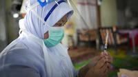 Petugas medis menyiapkan vaksin COVID-19 Pfizer untuk seorang wanita lansia di pedesaan Sabab Bernam, Selangor, Malaysia, Selasa (13/7/2021). Tim medis pergi dari rumah ke rumah di desa terpencil untuk menjangkau warga lansia dalam upaya meningkatkan program vaksinasi. (AP Photo/Vincent Thian)