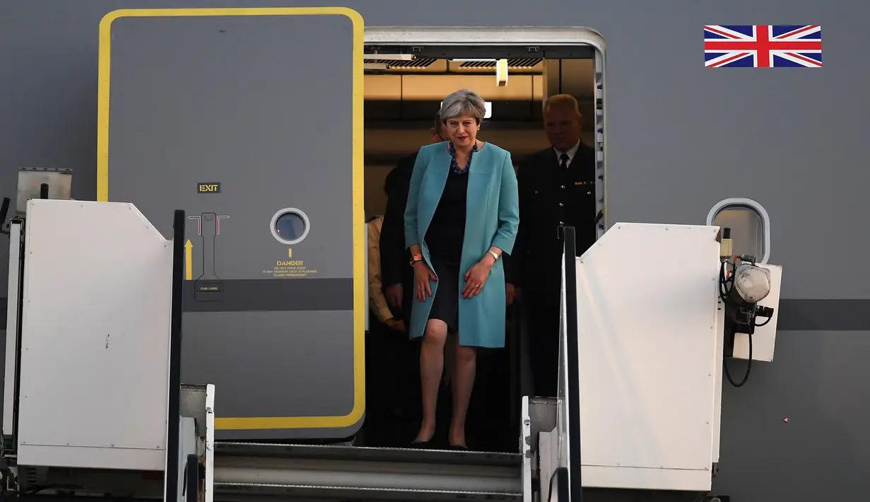 Perdana Menteri Inggris, Theresa May dan suaminya, Philip John, tiba di Hamburg, Jerman, Kamis (6/7). Sejumlah kepala negara telah tiba di Hamburg jelang pembukaan KTT G20 pada 7-8 Juli 2017.  (PATRIK STOLLARZ / AFP)