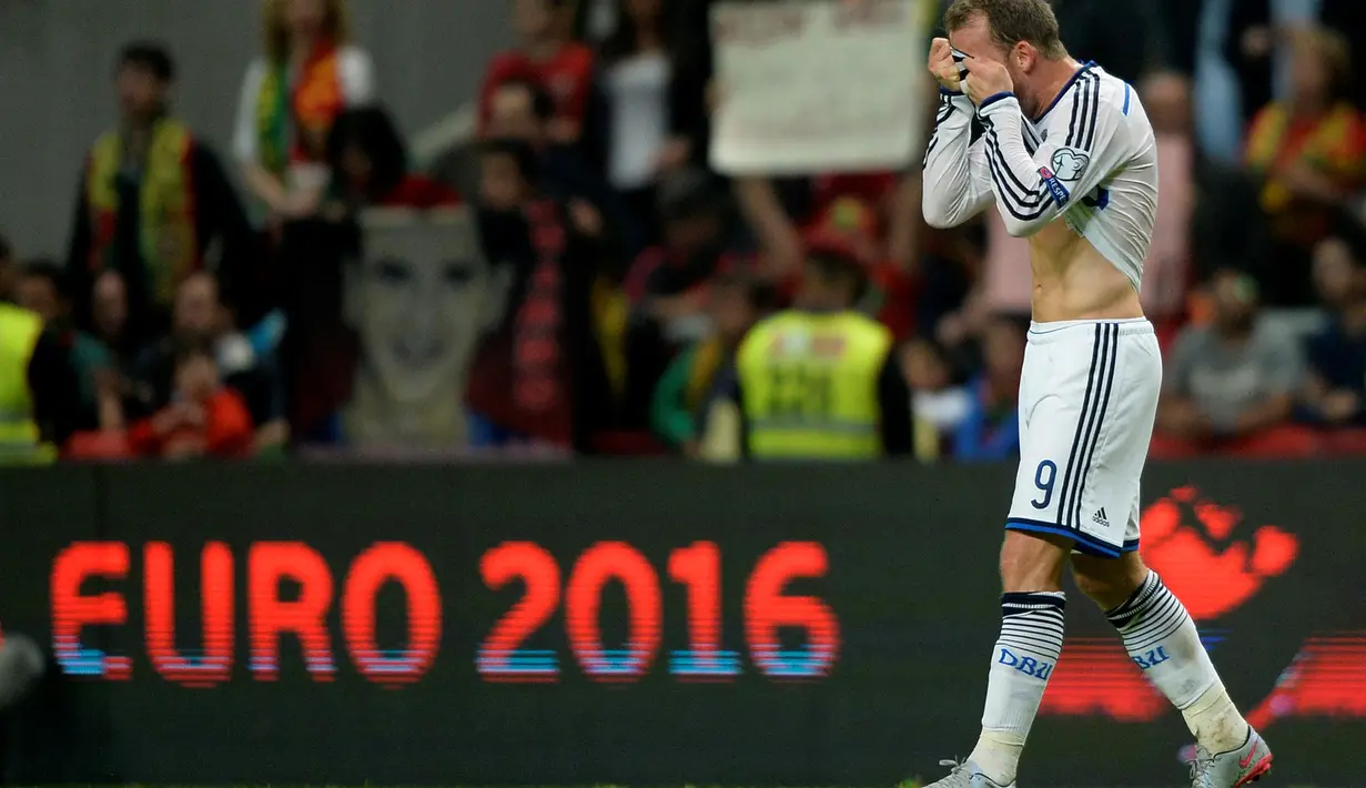 Pemain Denmark Michael Krohn-Dehli menutup mukanya setelah kalah dari Portugal pada laga Kualifikasi Piala Eropa 2016 Grup I di Municipal stadium, Braga, Kamis (8/10/2015). Portugal menang atas Denmark1-0. (AFP Photo/ Miguel Riopa)