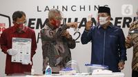 Ketua KPU Arief Budiman (tengah) bersama Wakil Ketua KPU Pramono Ubaid Tanthowi dan Anggota Bawaslu RI Mochammad Afifuddin saat memperlihatkan alat prosedur kesehatan dalam Launching Pemilihan Serentak Tahun 2020 di Gedung KPU RI, Menteng, Jakarta Pusat, Kamis (18/6/2020). (Liputan6.com/Johan Tallo)