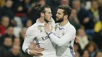 Pemain Real Madrid, Nacho mencoba menahan emosi Gareth Bale yang mendapat kartu merah di laga melawan Las Palmas. (AP Photo/Paul White)