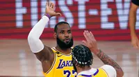 Pebasket Los Angeles Lakers, LeBron James dan Anthony Davis, melakukan selebrasi saat melawan Miami Heat pada gim pertama final NBA di Lake Buena Vista, Kamis (1/10/2020). Lakers menang dengan skor 116-98. (AP Photo/Mark J. Terrill)