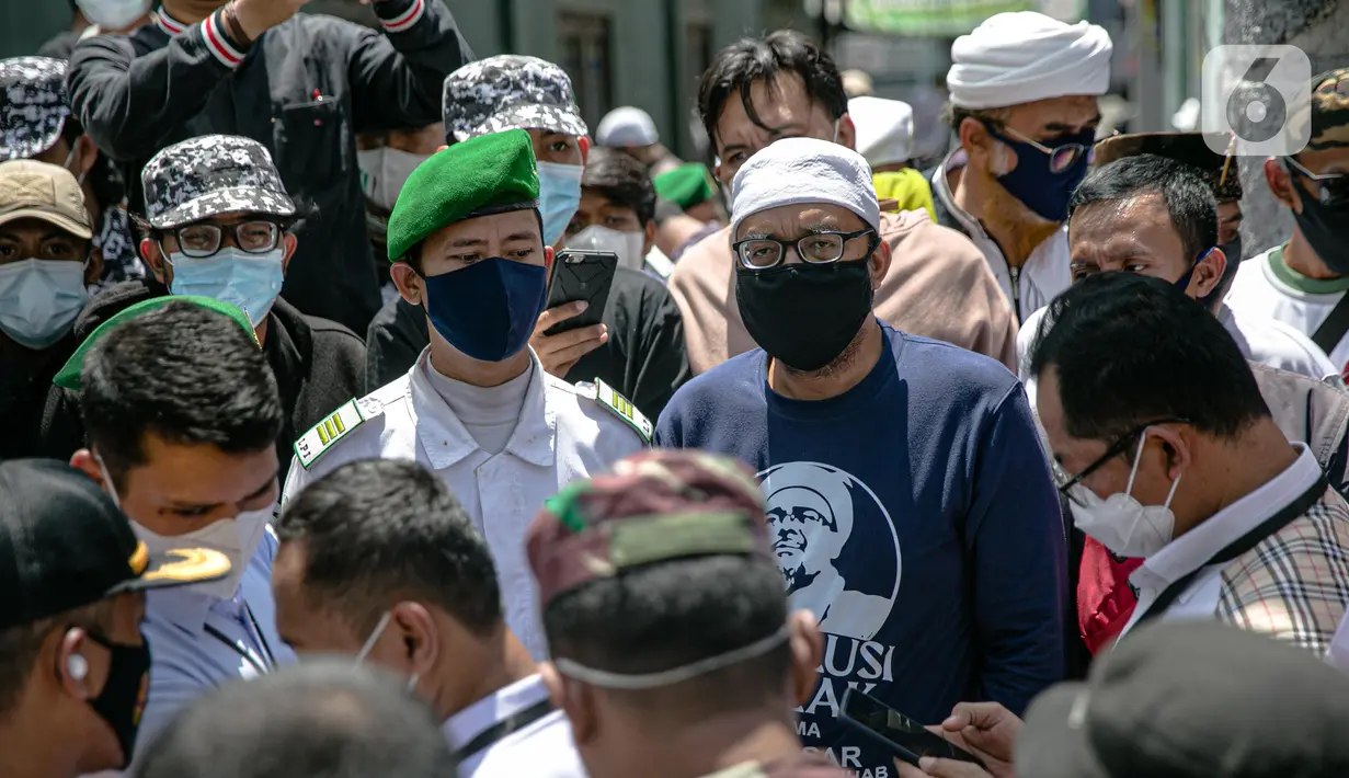 Anggota FPI mengadang anggota Polda Metro Jaya yang ingin memberi surat pemanggilan kepada Rizieq Shihab di kediamannya di Petamburan, Jakarta, Rabu (2/12/2020). Polisi kembali memanggil Rizieq Shihab terkait acara Maulid Nabi dan resepsi putrinya. (Liputan6.com/Faizal Fanani)
