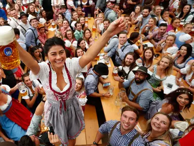 Seorang wanita merayakan pembukaan festival bir Oktoberfest ke-185 di Munich, Jerman, Sabtu (22/9). Festival bir terbesar di dunia ini diselenggarakan mulai 22 September hingga 7 Oktober 2018. (AP Photo/Matthias Schrader)