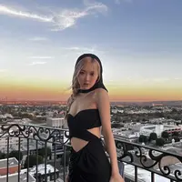 Dalam penampilan terbarunya, Rose BLACKPINK memesona dalam balutan black cut-out dress. Gaun ini juga memiliki head-cape yang menutupi sebagian kepalanya, menampilkan rambut Rose yang dikepang kecil. Foto: Instagram.