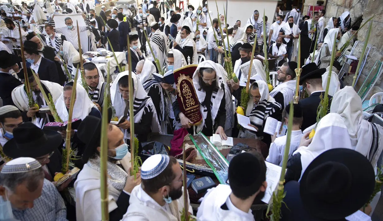 Pria Yahudi Ultra-Ortodoks berdoa selama hari raya Yahudi Sukkot di Tembok Barat, situs paling suci di mana orang Yahudi dapat berdoa di Kota Tua Yerusalem, Rabu (22/9/2021).  (AP Photo/Sebastian Scheiner)