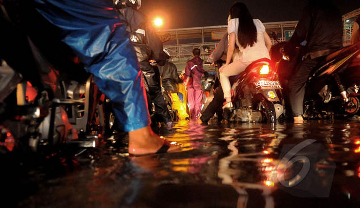 Hujan yang turun sejak dini hari tadi membuat ruas Jalan Daan Mogot, Jakarta, terendam banjir, akibatnya arus lalu lintas di jalan tersebut macet total, Senin (9/2/2015) malam. (Liputan6.com/Faisal R Syam)