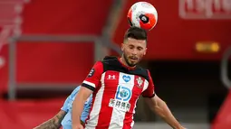Pemain Southampton Shane Long menjauhkan bola dari jangkauan bek Manchester City Joao Cancelo dalam lanjutan Liga Inggris di St. Mary Stadium, Minggu (5/7/2020).  Manchester City gagal memetik poin penuh setelah kalah tipis 0-1 saat bertandang ke markas Southamtpon. (AP Photo/Frank Augstein, Pool)