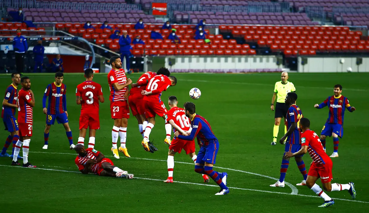 Pemain Barcelona Lionel Messi (kanan) melakukan tendangan bebas saat melawan Granada pada pertandingan La Liga di Stadion Camp Nou, Barcelona, Spanyol, Kamis (29/4/2021). Barcelona kalah 1-2. (AP Photo/Joan Monfort)