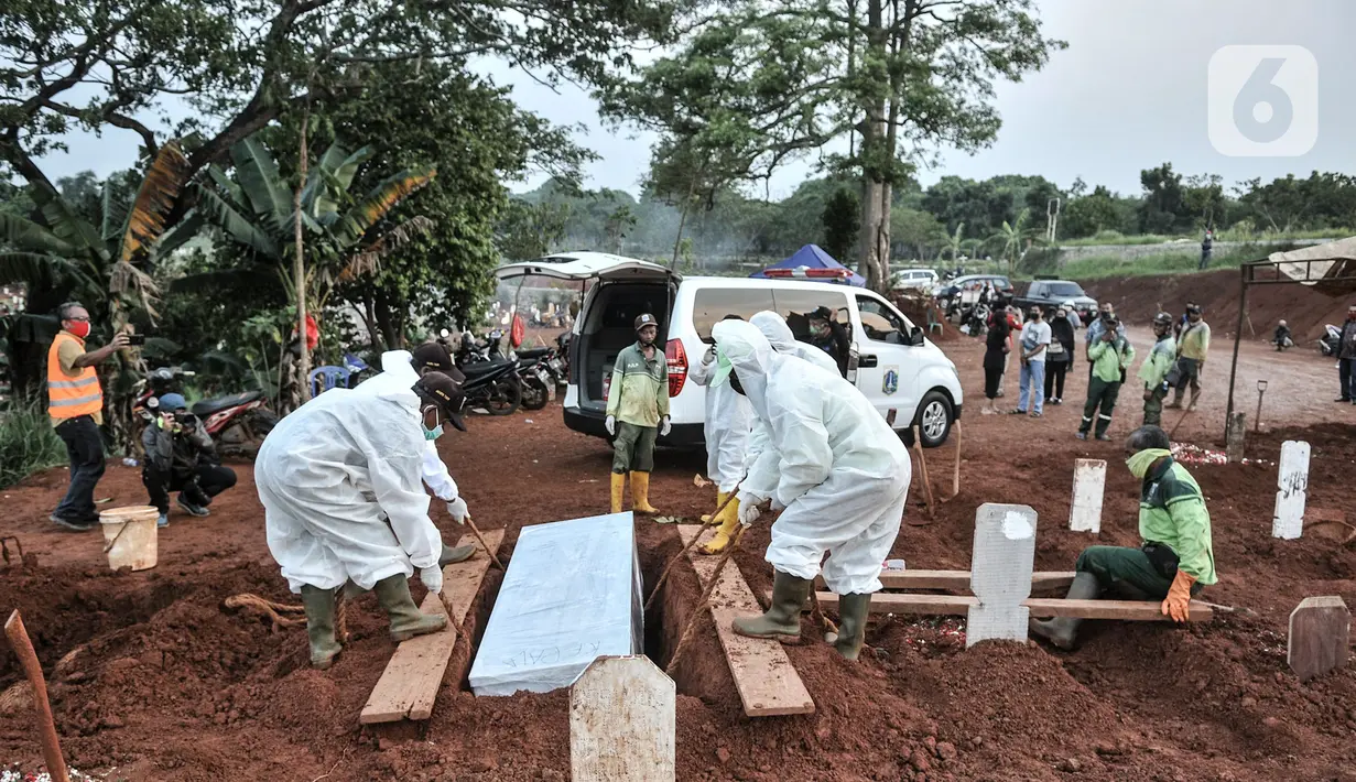 Petugas mengenakan alat pelindung diri dan baju hazmat saat proses pemakaman protap Covid-19 di TPU Pondok Ranggon, Jakarta, Senin (28/9/2020). (merdeka.com/Iqbal S. Nugroho)