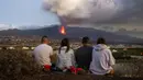 Warga menyaksikan lava mengalir dari gunung berapi yang meletus di Canary, Pulau La Palma, Spanyol, 26 Oktober 2021. Aliran lava baru telah muncul setelah runtuhnya sebagian kawah dan mengancam akan menelan daerah yang sebelumnya tidak terpengaruh. (AP Photo/Emilio Morenatti)