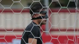 Andritany menggunakan masker pelindung wajah saat sesi latihan tim jelang laga Gojek Liga 1 bersama Bukalapak di Stadion PTIK, Jakarta, Senin (25/6/2018). Andritany berpeluang tampil saat Persija melawan Persebaya. (Bola.com/Nick Hanoatubun)