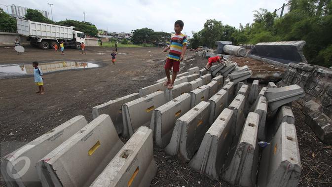 Anak-anak bermain diatas beton di sekitar pembangunan Taman Bersih Manusiawi dan Wibawa (BMW) di Jakarta Utara, Selasa (7/3). Pemprov DKI Jakarta akan melanjutkan kembali pembangunan taman dan stadion BMW. (Liputan6.com/Immanuel Antonius)