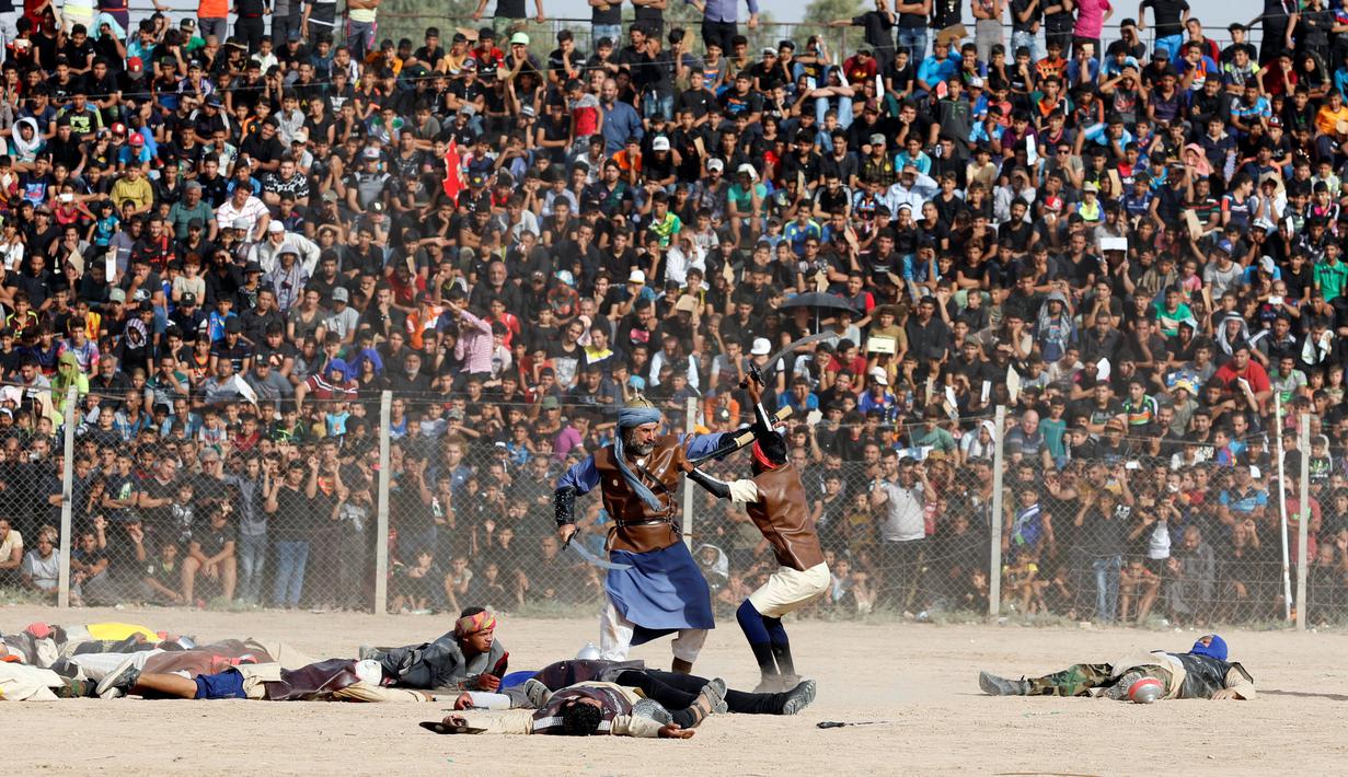 Sejumlah umat Syiah menyaksikan reka ulang adegan Pertempuran Karbala yang menewaskan Husain bin Ali, di Sadr City, Baghdad, Irak, Rabu (12/10). Pertempuran Karbala terjadi pada 10 Muharram 61 H abad ke-7 Masehi. (REUTERS/Ahmed Saad)