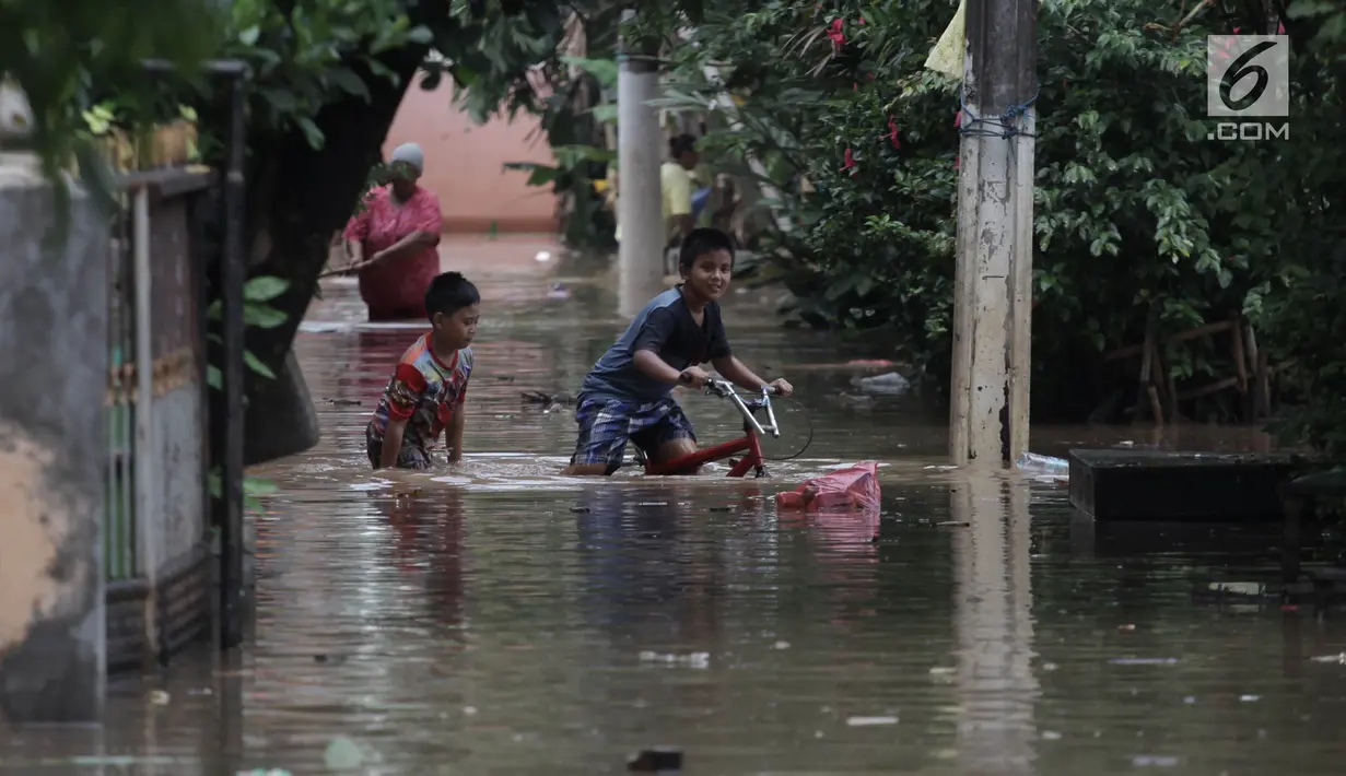 Anak-anak bermain air saat banjir merendam kawasan Cipinang Melayu, Jakarta Timur, Senin (5/2). Akibat hujan deras yang mengguyur sebagian besar wilayah Jakarta permukiman di Cipinang Melayu tergenang air setinggi 30-40 cm. (Liputan6.com/Arya Manggala)