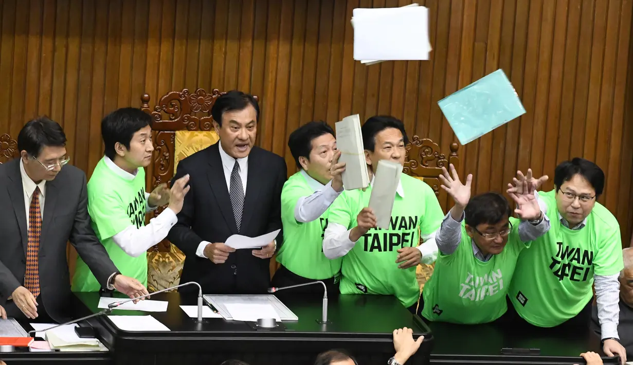 Anggota parlemen dari Partai Progresif Demokratik (DPP) melempar berkas saat melakukan protes di Parlemen di Taipei (20/4). Para legislator tersebut bentrok saat membahas rancangan undang-undang untuk mereformasi sistem pensiun militer.(AFP Photo/Sam Yeh)