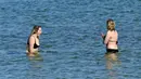 Warga berenang di sebuah pantai di Melbourne, Australia, Kamis (19/8/2021). Melbourne melewati 200 hari dalam lockdown keras sejak dimulainya pandemi COVID-19. (William WEST/AFP)