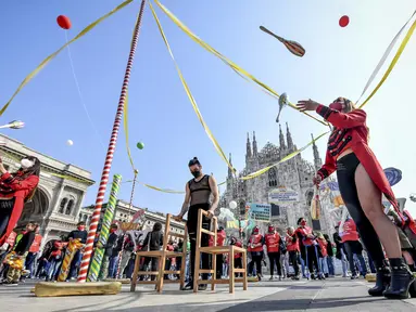 Seniman sirkus tampil di depan katedral gothic Duomo selama demonstrasi oleh pekerja sirkus di Milan, Italia utara (26/3/2021). Mereka menuntut lebih banyak dukungan dari pemerintah Italia karena kegiatan mereka ditutup sejak dimulainya wabah COVID-19. (Claudio Furlan/LaPresse via AP)