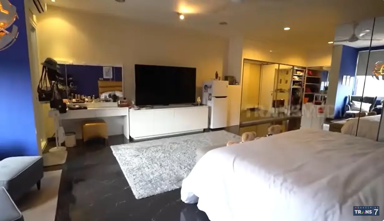 Kamar utama juga tampak luas dengan beberapa sofa dan tempat tidur dengan hiasan boneka. Sementara cat dinding biru dibeberapa dinding membuat kamar itu lebih ceria. [Youtube/TRANS7 OFFICIAL]