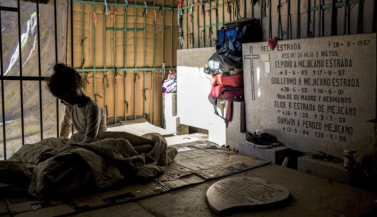 Seorang gadis beristirahat di tempat perlindungan darurat di Pemakaman Umum Selatan di Caracas, pada 10 Februari 2021. Makam yang dirusak telah menjadi rumah bagi banyak tunawisma di Venezuela. (Pedro Rances Mattey / AFP)