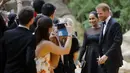 Pangeran Harry dan Meghan Markle tiba menghadiri pemutaran perdana film The Lion King di London (14/7/2019). Duchess of Sussex tampil menawan dalam balutan gaun hitam dengan detail lebar di bagian bawah rok. (AFP Photo/Tolga Akmen)