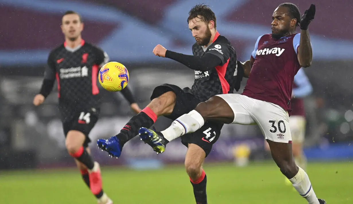 Pemain Liverpool, Nathaniel Phillips, berebut bola dengan pemain West Ham United, Michail Antonio, pada laga Liga Inggris di Stadion London, Minggu (31/1/2021). Liverpool menang dengan skor 3-1. (Justin Setterfield/Pool via AP)