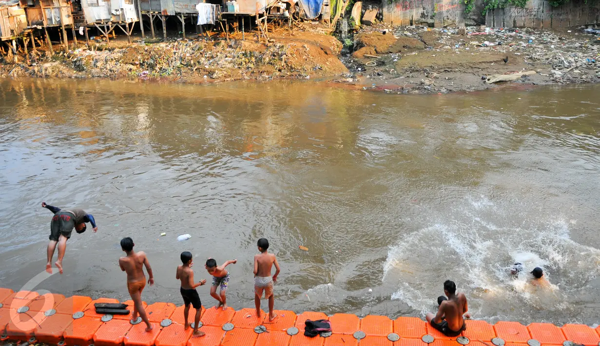 Warga berenang di bantaran sungai Ciliwung, Jakarta, Rabu (18/5/2016). Relokasi warga bantaran sungai Ciliwung akan dilakukan secara bertahap karena rumah susun (rusun) masih dalam tahap pembangunan. (Liputan6.com/Yoppy Renato)
