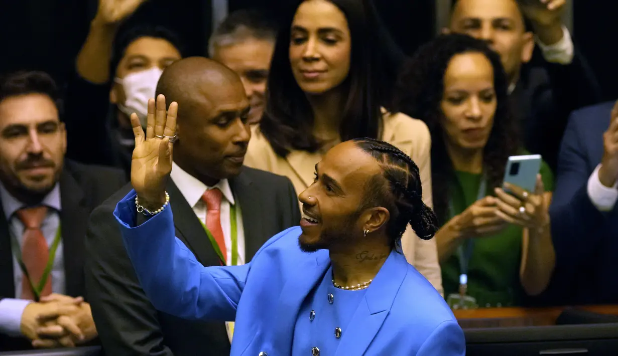 Pembalap Formula 1 Mercedes asal Inggris, Lewis Hamilton menyapa kerumunan di Chamber of Deputies saat upacara menerima gelar Warga Kehormatan Brasil di Brasilia, Brasil, Senin (7/11/2022). Anggota kongres Andre Figueiredo mengusulkan hal itu pada November lalu setelah Grand Prix Brasil yang dimenangkan Hamilton. (AP Photo/Eraldo Peres)