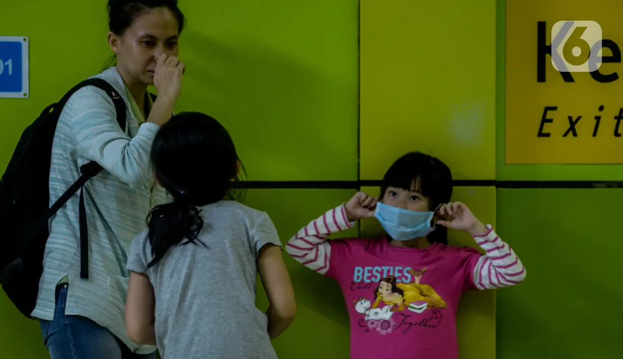 Seorang anak mengenakan masker saat berada di Stasiun Gambir, Jakarta Pusat, Jumat (31/01). Dalam rangka pencegahan Virus Corona, PT Kereta Api Indonesia (persero) melakukan sosialisasi kepada penumpang dengan membagi-bagikan masker di stasiun Gambir. (merdeka.com/Imam Buhori)