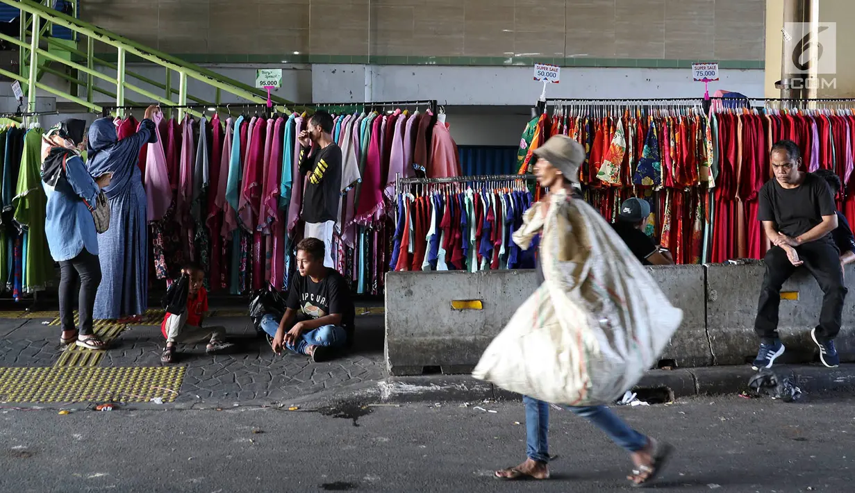 Warga berjalan di depan deretan pedagang di depan Gedung Pasar Tanah Abang, Jakarta, Jumat (22/6). Sebagian pedagang terpaksa menggelar lapak di luar gedung akibat belum dibukanya kembali Pasar Tanah Abang usai Lebaran. (Liputan6.com/Immanuel Antonius)
