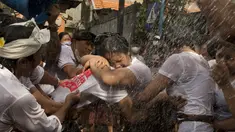 Sepasang remaja berpelukan selama tradisi Omed-omedan (cium-ciuman) di Denpasar, Bali, Jumat (4/3/2022). Tradisi Omed-omedan dilakukan sehari setelah Hari Raya Nyepi saat Ngembak Geni yang digelar sebagai wujud tolak bala. (AP Photo/Firdia Lisnawati)