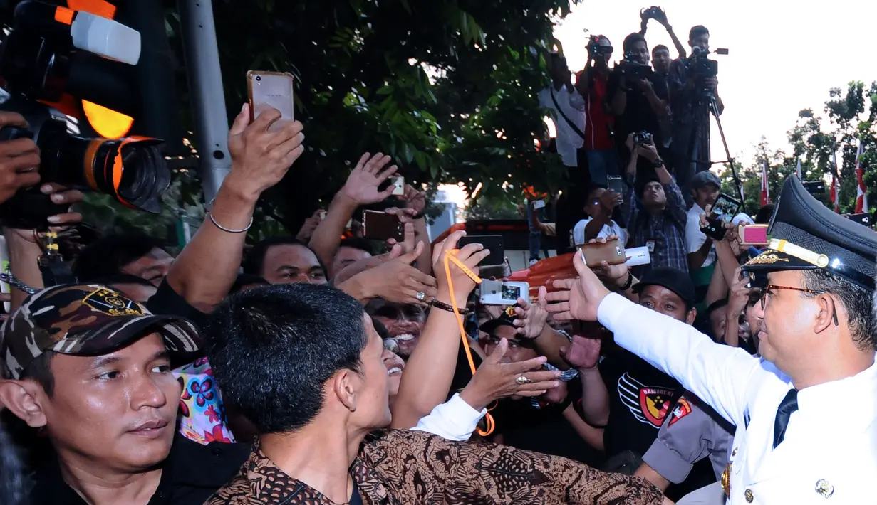 Gubernur DKI Jakarta. Anies Baswedan menyalami warga saat akan masuk Balai Kota, Senin (16/10). Ribuan warga menyambut kedatangan Anies Baswedan dan Sandiaga Uno pasca dilantik sebagai Gubernur dan Wakil Gubernur. (Liputan6.com/Helmi Fithriansyah)