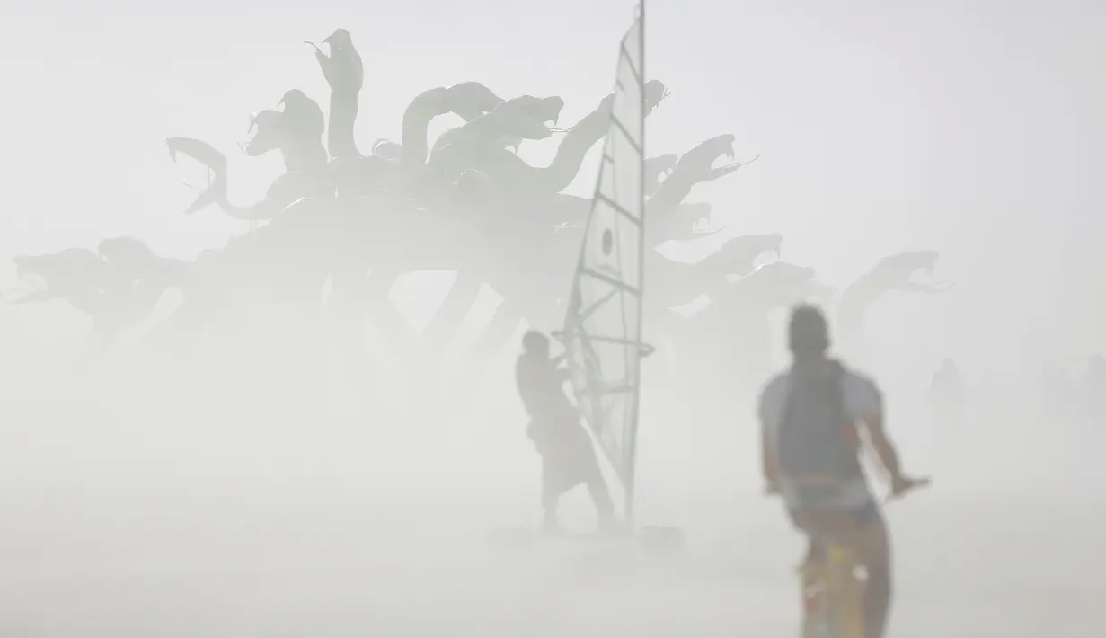 Angin disertai debu menutupi peserta yang tengah menggunakan selancar dan sepeda dalam Festival Burning Man, di padang pasir Black Rock, Nevada, Amerika Serikat (30/08). Lahan seluas 3.800 hektar digelar untuk Burning Man 2016. (REUTERS/Jim Urquhart)
