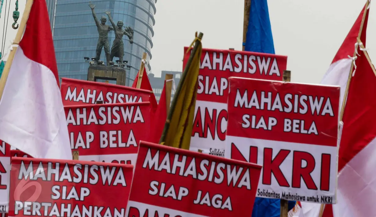 Mahasiswa membentangkan tulisan saat melakukan longmarch dari Bundaran HI menuju Istana, Jakarta, Senin (21/11). Mereka menyatakan sikap untuk menjaga keutuhan NKRI dan Ideologi Pancasila. (Liputan6.com/Faizal Fanani)