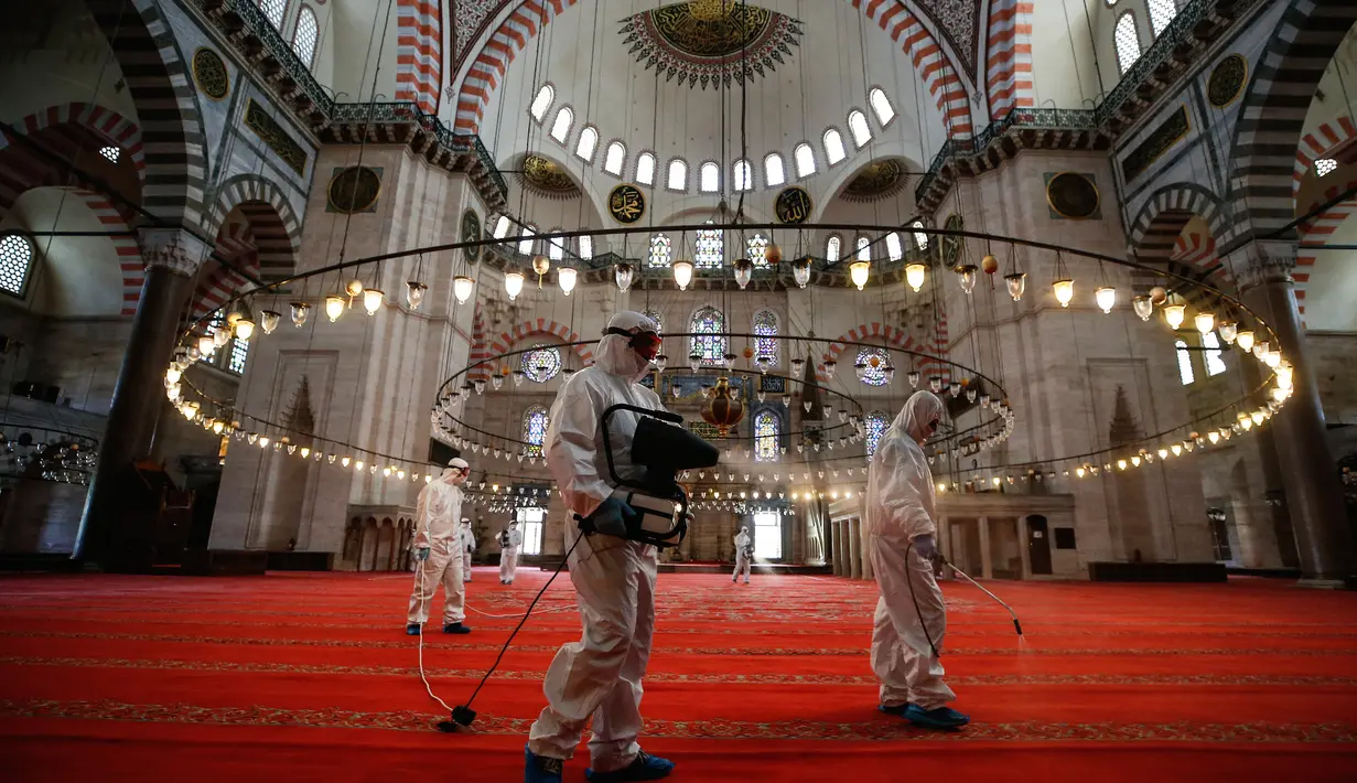 Pekerja mengenakan pakaian pelindung menyemprotkan disinfektan bagian dalam Masjid Suleymaniye yang bersejarah pada hari ketiga Idul Fitri di Istanbul, Selasa (26/5/2020). Beberapa masjid didisinfektan sebelum dibuka kembali pada 29 Mei usai ditutup selama lebih dari enam minggu. (AP/Emrah Gurel)