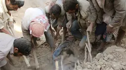 Seorang bocah ditemukan tertimbun puing usai serangan udara oleh Jet Tempur Saudi di Sanaa, Yaman, Rabu (31/8). Serangan tersebut ditujukan untuk melemahkan kelompok Houthi. (REUTERS / Naif Rahma) 