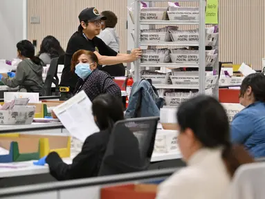 Petugas pemilu menyiapkan surat suara yang masuk melalui pos untuk penghitungan di Pusat Pemrosesan Surat Suara Wilayah Los Angeles di California pada, Senin 4 November 2024 malam. (Robyn Beck/AFP)