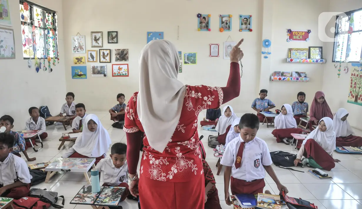 Guru saat mengajarkan para murid di salah satu kelas Sekolah Dasar Negeri (SDN) Mekarsari 05, Tambun Selatan, Kabupaten Bekasi, Jawa Barat, Kamis (28/7/2022). Sudah dua pekan berlangsung sejak dimulainya Tahun Ajaran Baru 2022 murid kelas IV dan V di SDN Mekarsari 05 mengikuti kegiatan belajar tanpa fasilitas meja dan kursi. (merdeka.com/Iqbal S. Nugroho)