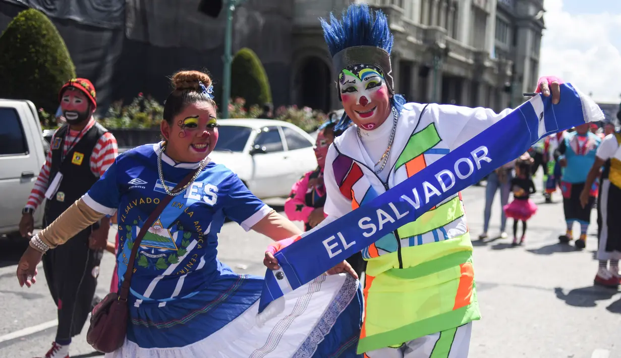 Dua badut Salvador berpose selama parade pada Konvensi Badut Regional ke-5 di kota Guatemala, Rabu (19/9). Dalam acara tersebut, dengan kostum warna-warninya mereka berparade menelusuri jalanan pusat sejarah Guatemala City. (AFP / Johan ORDONEZ)