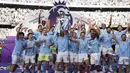 Para pemain Manchester City mengangkat trofi juara Liga Inggris 2023/2024 usai menaklukkan West Ham United pada laga pekan ke-38 yang digelar di Etihad Stadium, Minggu (19/5/2024) malam WIB. (AP Photo/Dave Thompson)