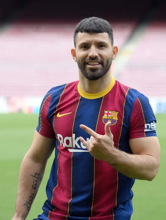 Penyerang Manchester City asal Argentina, Sergio Aguero berpose selama presentasi resminya sebagai pemain baru Barcelona di stadion Camp Nou, Spanyol (31/65/2021).  Barcelona dan Sergio Aguero sama-sama sepakat untuk menyelipkan klausul pelepasan dalam kontraknya. (AFP Photo/Lluis Gene)