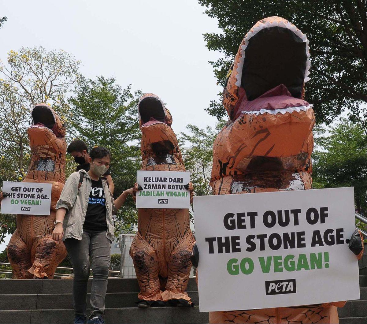 Sejumlah aktivis People for the Ethical Treatment of Animals (PETA) memakai kostum dinosaurus saat menggelar aksi di kawasan Dukuh Atas, Jakarta, Selasa (24/10/2023).&nbsp;