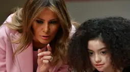 Melania Trump mengunjungi anak-anak yang dirawat rumah sakit National Institutes of Health untuk merayakan Hari Valentine, Maryland, Kamis (14/2). Nuansa valentine sangat terasa dalam busana serba merah muda yang dipakai Melania saat itu (MANDEL NGAN/AFP)