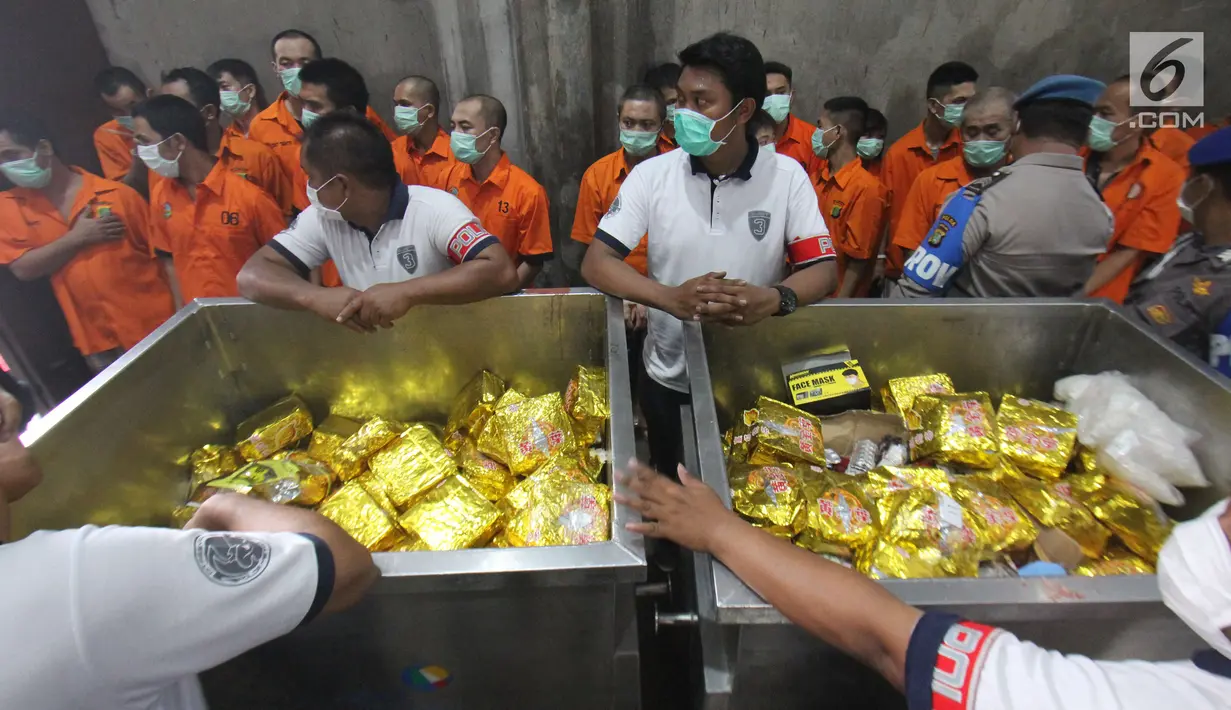 Petugas menunjukan barang bukti narkoba berserta tersangka di Bandara Soekarno-Hatta, Tangerang, Selasa (15/08). Pemusnahan ini mendapat penghargaan dari MURI sebagai pemusnahan Narkoba terbesar di Indonesia. (Liputan6.com/Helmi Afandi)